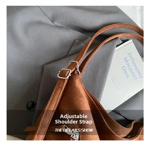 Détail de la bandoulière réglable en daim avec boucle argentée et fermeture à glissière