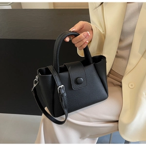 Détail du mini sac à main noir en cuir grainé avec ferrures argentées et bandoulière