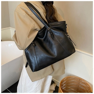 Détail du sac cabas en similicuir noir avec coutures verticales et rivets métalliques