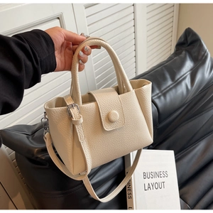 Détail du sac seau blanc cassé en cuir grainé avec anses rondes et bandoulière