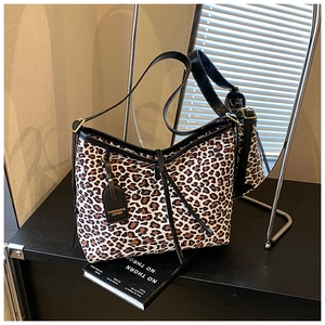 Detail shot of leopard print tote bag with black leather handle and fashion hangtag