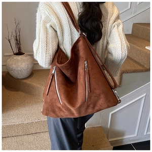 Détail d'un sac cabas marron foncé mat avec zips argentés et texture en daim raffiné