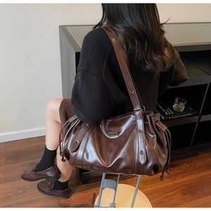 Détail du sac cabas marron foncé brillant avec cordon et sangles décoratives