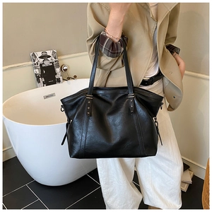 Détail d'un grand sac fourre-tout noir avec rivets étoiles argentés et cuir synthétique