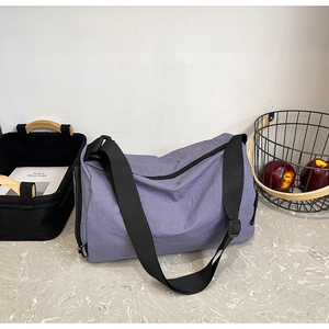 Detail of purple nylon bag texture with adjustable black strap and fashion label
