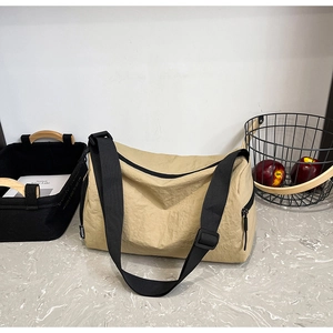 Detail of khaki nylon crossbody bag with natural wrinkled texture and black strap