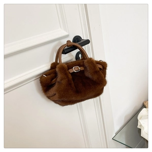 Detailansicht der braunen Webpelz-Handtasche mit Lederriemen und Metallschnalle