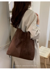 Detailaufnahme einer braunen Vintage-Matt-Shopper-Tasche mit breitem Schultergurt am Model