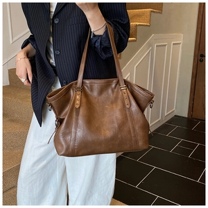 Vue détaillée d'un grand sac cabas vintage en cuir marron avec rivets en forme d'étoile