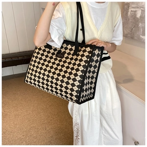 Detail of checkered canvas tote bag with black square label and large capacity interior