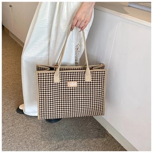 Detail of checkered tote bag showing beige strap and I LOVE YOU HAPPY leather patch