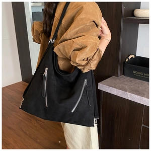 Détail d'un grand sac cabas noir en daim avec doubles fermetures éclair argentées