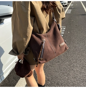 Detail view of large coffee brown retro tote bag with side zippers and leather patch