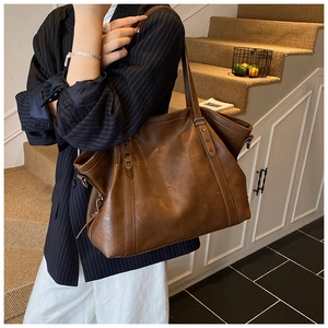 Grand sac cabas marron rétro avec rivets étoilés porté par un mannequin en style chic