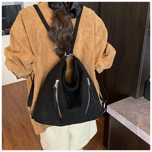 Vue arrière d'un sac à dos en daim noir avec fermetures éclair parallèles et design rétro