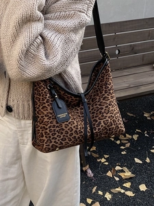 Vintage leopard print shoulder bag with black leather trim and gold protective feet