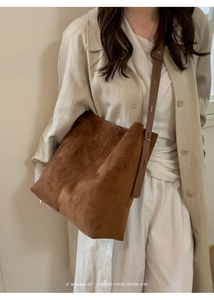 Braune Wildleder-Einkaufstasche am Modell mit minimalistischem Retro-Stil und viel Platz