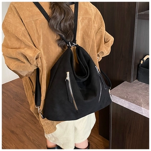 Vue détaillée du grand sac à bandoulière noir mat avec poches zippées sur un mannequin