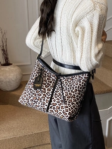 Retro leopard print oversized tote bag with black leather straps styled as a shoulder bag