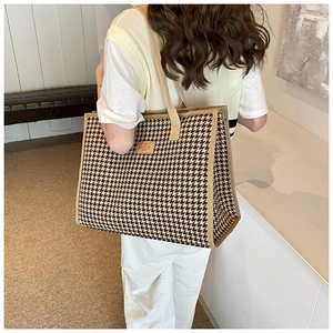Detailed close-up of brown houndstooth canvas tote bag with Love You Happy leather label