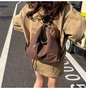 Brown canvas tote bag with round coin purse and decorative side zipper detail
