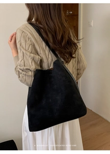 Detail der schwarzen Wildleder-Tote-Bag mit verstellbarem Schultergurt am Model