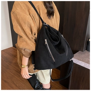 Détail d'un sac bandoulière en cuir mat noir avec bandoulière réglable porté par un mannequin
