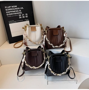 Detail view of woven bucket bags in four colors with floral scarf handles and gold hardware
