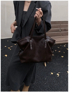 Détail du grand sac cabas en cuir marron avec rivets en étoile argentés et boucle en métal