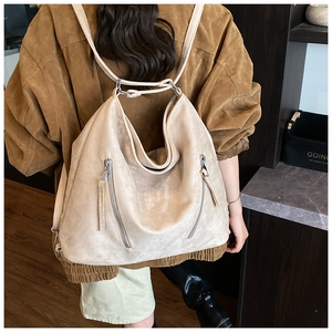 Détail du sac à dos vintage en daim beige avec double fermeture et texture souple