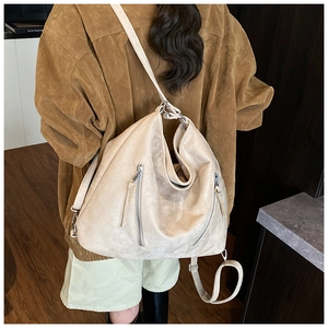 Détail du sac hobo crème mat avec fermetures éclair argentées et large bandoulière réglable