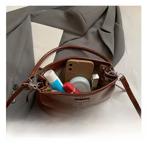 Vue intérieure du sac en cuir marron montrant la capacité pour téléphone et cosmétiques