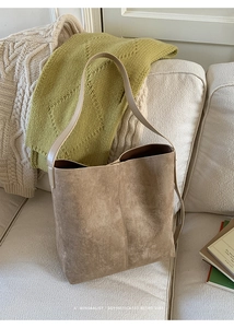 Detailansicht der braunen Wildleder-Beuteltasche auf Sofa im minimalistischen Retro-Stil