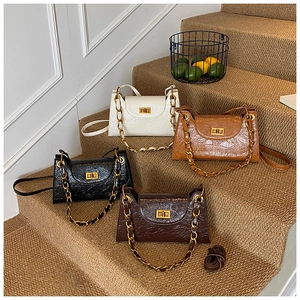 Detail of four retro faux leather handbags in white, black, camel and dark brown colors