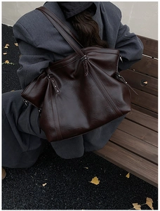 Vue détaillée du grand sac cabas en cuir marron foncé avec rivets argentés et style urbain