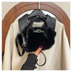 Detailansicht der schwarzen Pelzhandtasche mit Lederriemen und silberner Schnalle