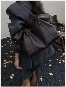 Détail d'un grand sac cabas en cuir marron café avec boucles métalliques et des rivets