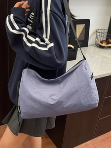 Light purple nylon crossbody messenger bag with zip closure and fashion tag detail