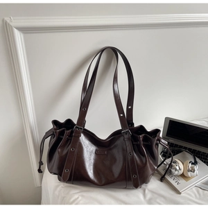 Détail d'un grand sac fourre-tout marron foncé avec cordon de serrage et bandoulière