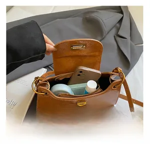 Detailed view of the caramel leather crossbody bag interior showing daily essentials