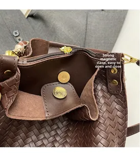 Detail of magnetic snap closures and secure zipper compartment on dark brown woven bag