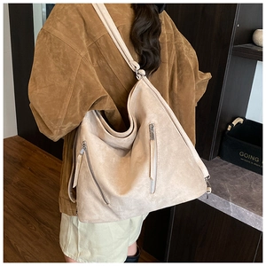Détail du grand sac hobo beige en daim mat avec fermeture éclair latérale argentée