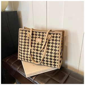 Detail of checkered canvas tote bag showing dark brown pattern and durable handle