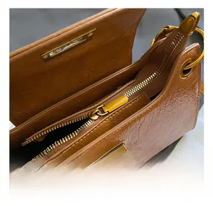 Close-up of caramel brown leather bag with premium gold zipper and metal hardware details