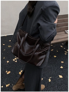 Détail d'un grand sac cabas rétro en cuir ciré marron foncé avec une texture élégante
