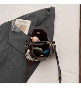 Interior detail of brown leather bucket bag showing spacious main compartment and scarf