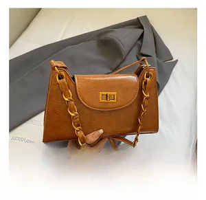 Detail showing the brown pleated leather texture and golden twist lock on the handbag
