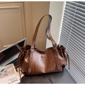 Détail du sac cabas en cuir PU marron avec cordon de serrage et boucle argentée réglable