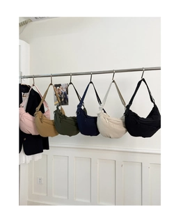 Showcase of minimalist crescent crossbody bags in six colors including pink, beige, and black
