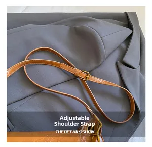 Detail of adjustable brown faux leather shoulder strap with high-quality gold metal buckle